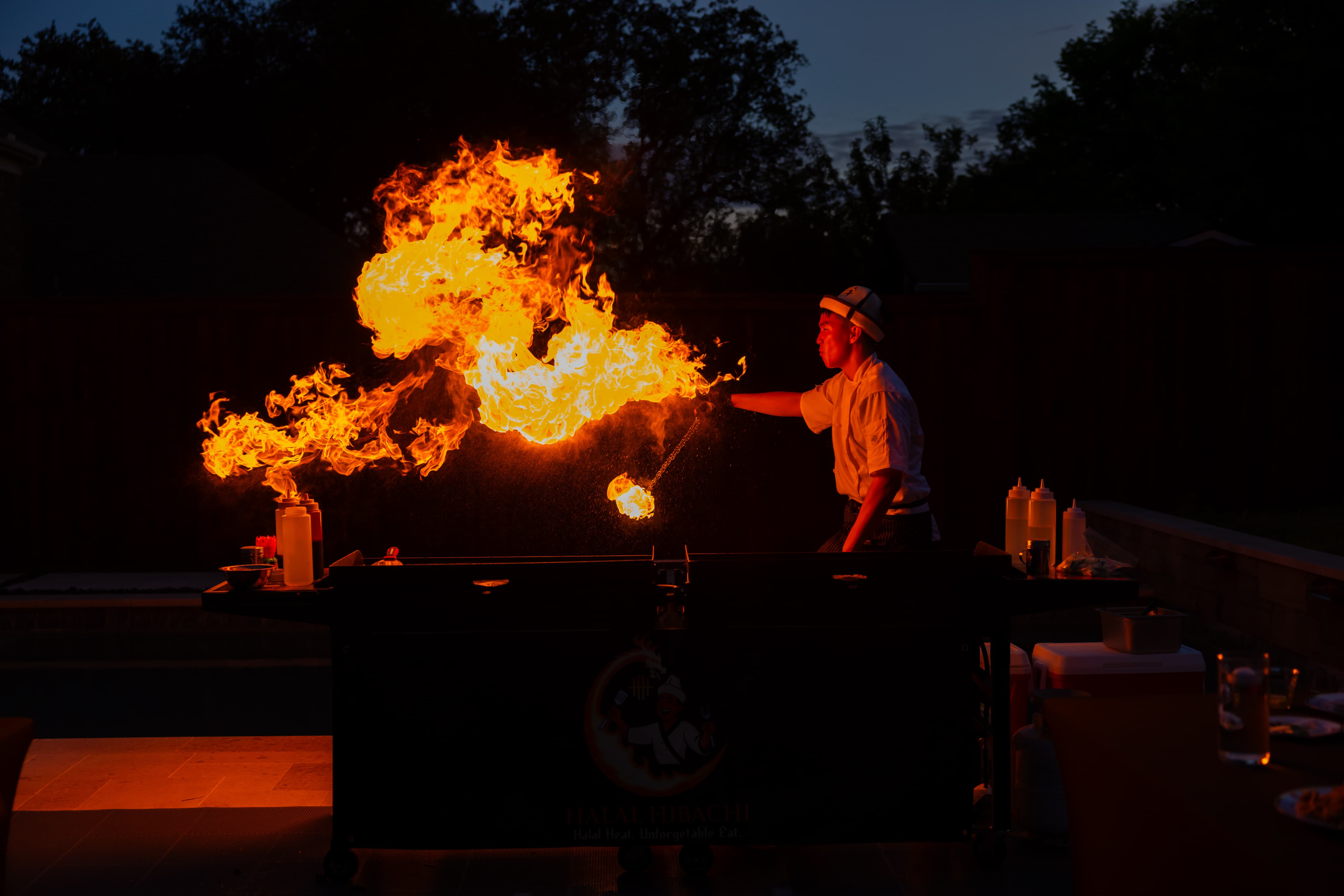 Professional chef cooking with dramatic flames in modern kitchen